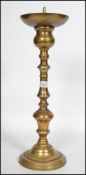 A large early 20th century ecclesiastical Church turned pricker candlestick raised on a large four