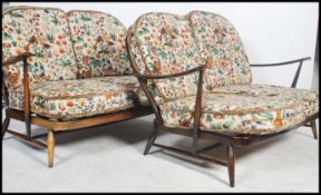 A pair of Ercol ' Windsor ' pattern 2 seat sofa settee's. Each with tapestry William Morris inspired