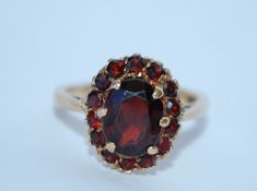 A 9ct gold and garnet cluster ring. Marked 9ct tests 9ct gold. Size L. Weight 3.4g.