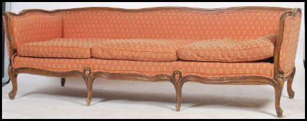 A superb early 20th century french fauteuil sofa being raised on carved cabriole legs with show wood