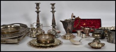 A large collection of silver plated wares to include a pair of large candlesticks, a 4 person egg