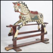 An early 20th Collinson child's rocking horse. Raised on a wooden glider, the dapple painted horse