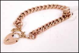 A 9ct gold curb bracelet havig a heart shaped locket measuring 18cm in llength and weighing 14g