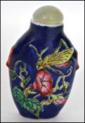 A Chinese ceramic hand painted scent bottle having a Jade stopper atop decorated with Praying