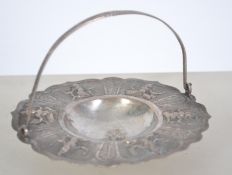 An Indian white metal bon bon dish with scrolled handle. the dish with central recess, cast in