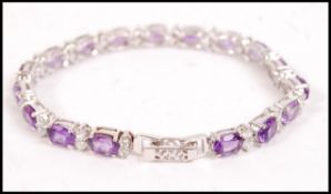An impressive silver amethyst and cz adorned ladies tennis bracelet, each being bar linked and