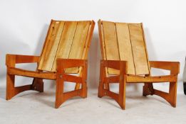 A pair of large garden chairs constructed of pine having shaped quadrille style legs and heavy
