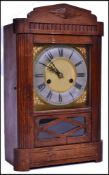 An oak eight-day pendulum mantel clock having a 2 train movement with a gilt brass face and