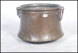 An 19th century / early 20th century copper pot / cauldron log coal bin with twin loop handles to