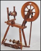 A vintage 20th century pine wood spinning wheel raised on turned legs with wheel and arm to top.