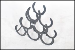 A mid-century scratch built ebonised metal wine rack being made from welded horse shoes.