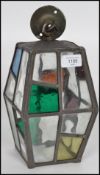 An early 20th century Arts & Crafts hexagonal glass and brass porch lantern, the stained glass