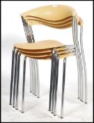 A set of 4 stacking chairs by Brune Dreki in yellow plastic and tubular chrome frames having a cow