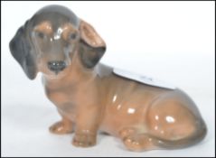 A Royal Copenhagen ceramic figurine of dachshund dog in a seated position 3140 with makers stamp