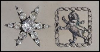 Two vintage early 20th century silver brooches, the first in the form of a star having paste stones,