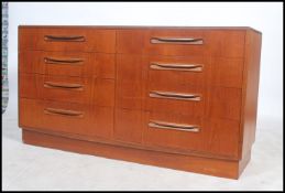 A 1970's G-Plan teak wood Kelso Pattern double chest of drawers being raised on an inset plinth with
