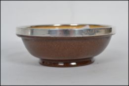 A studio art pottery bowl with a hallmarked silver rim for James Sherwood 1910 with notation '