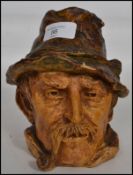 A vintage 20th century studio pottery lidded tobacco jar in the form of a pipe smoking gent with his