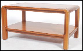 A retro 1970's Danish influence teak wood coffee / occasional table being raised on tapering legs