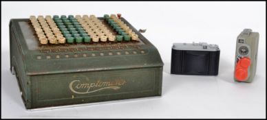 A vintage industrial comptometer counting machine along with a pair of 35mm cameras, one being a