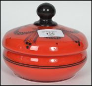 A 19th century glass lidded conserve pot in red having a black ball finial lid with a hand painted