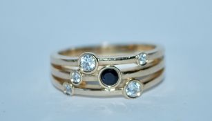 A contemporary hallmarked 9ct gold band ring set with a sapphire and CZ. Hallmarked Birmingham. Size