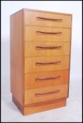 A 1970's G-Plan teak wood Kelso Pattern chest of drawers being raised on an inset plinth with