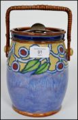 A Royal Doulton tube lined tobacco jar / biscuit barrel having a wicker swing handle with sealed