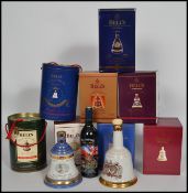 A group of 10 Bells Whiskey commemorative bell shaped ceramic decanters all unused most in