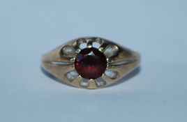 A hallmarked 9ct gold ring set with a central garnet. Hallmarked Birmingham. Size O. Weight 2.4g