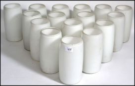 A 20th century collection of tall cylindrical glass milk lamp shades.