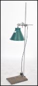 An Industrial mid century laboratory phial stand having applied enamel pendant light with flex.