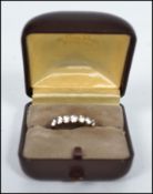 A vintage hallmarked 9ct gold 7 stone ring having split shoulders with the stones set in a prong