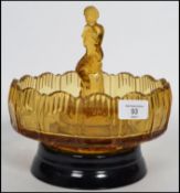 An early 20th century pressed glass centre piece bowl having a raised edge with central figure of