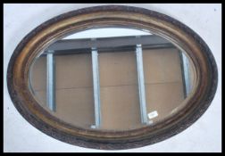 A Victorian oval wall hanging mirror having a worked edge and acanthus leaf detailing,