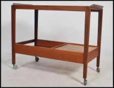 A vintage 1950's teak two tier trolley having a curved edge top and a drawer to the first tier