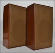 A pair of retro 1970s solid oak speakers of rectangular form having grille covers.