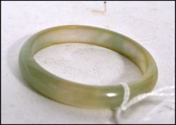 A Chinese pale Celadon to green jade bangle being  unsigned in a  good condition