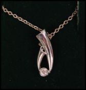 A white gold and diamond adorned pendant necklace in the form of a jewellers tweezers holding a