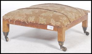 An Edwardian mahogany footstool of square form being raised on mahogany squared legs with brass