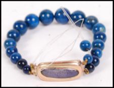 A vintage 9ct gold and stone agate bead bangle bracelet with lozenge shaped clasp with amethyst type