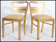 A pair of 1950's town hall chairs having gilt finisha with shaped back rests and tapestry
