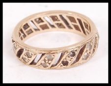 A 9ct gold and paste stone channel set vintage ladies eternity ring with pierced centres being