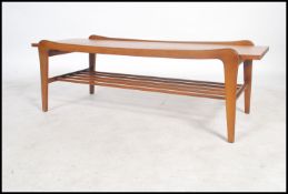 A mid-century teak wood coffee table comprised of a bevelled top leading into straight shaped legs