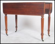 A Victorian mahogany pembroke table being raised on turned legs with drawer to end. The drop