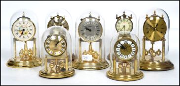 A collection of seven 20th century decorative domed glass anniversary clocks, the bulk by Kundo (