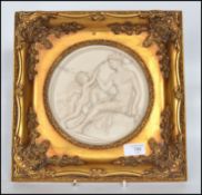 A reconstituted marble plaque decorated in relief depicting a women and cherub in a decorative