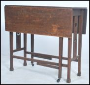An early 20th century Arts & Crafts solid  oak gate leg table raised on splayed feet with tulip