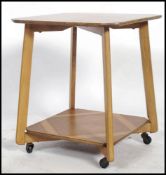 A 1930's Art Deco walnut qtr veneer lamp table having angular supports with twin tiers being qtr