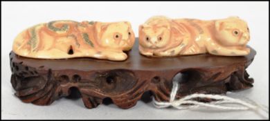 A very fine carved 19th century ivory Chinese charm of resting cats ? set upon a well carved